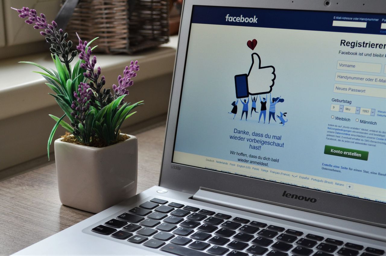 who-we-are A Lenovo laptop displaying Facebook login beside a lavender plant indoors.